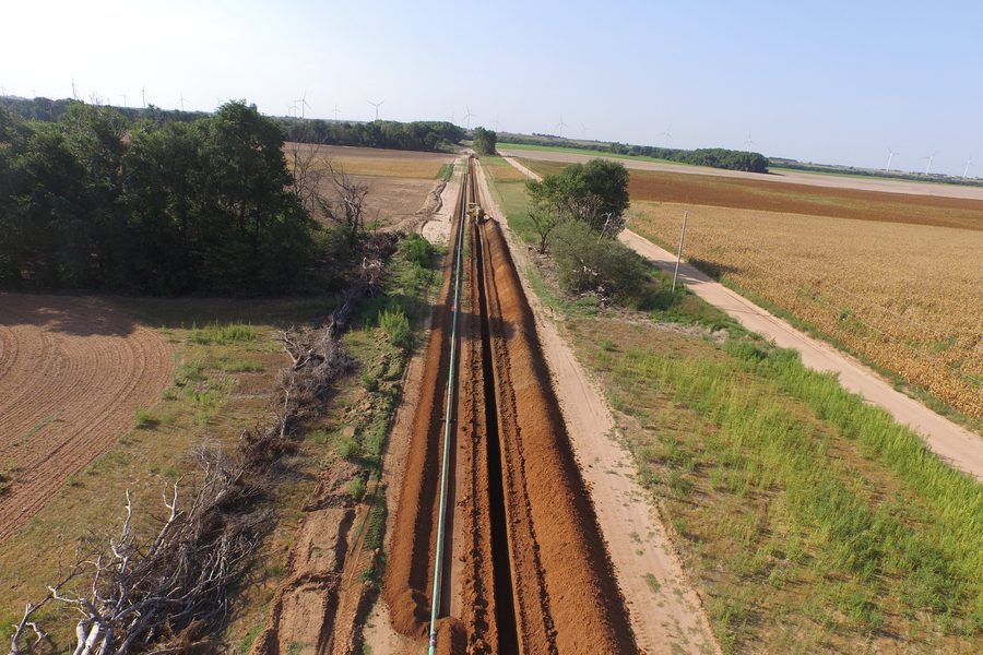 Aerial view of a graded pipeline right-of-way running between fields