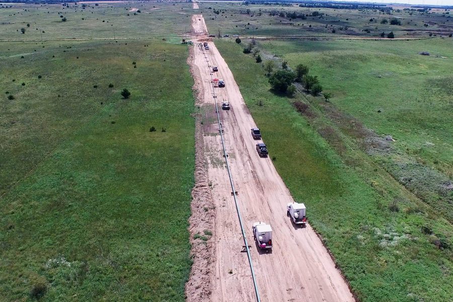 Aerial view of a pipeline construction spread with trucks working along the right-of-way